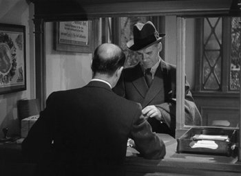 Movie still from “Dodsworth” (1936), directed by William Wyler – An old photo of a man in a hat looking at a man in a suit; Medium shot, Over the shoulder angle