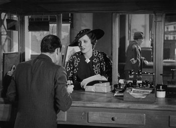 Movie still from “Dodsworth” (1936), directed by William Wyler – An old photo of a man and a woman at a counter; Medium shot, Over the shoulder angle