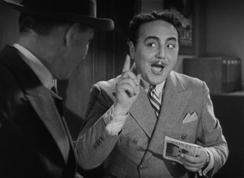 Movie still from “Dodsworth” (1936), directed by William Wyler – A man in a suit and tie holding an object; Close Up shot, Low angle