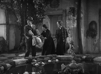 Movie still from “Dodsworth” (1936), directed by William Wyler – A man and two women standing in front of a pond; Wide shot, High angle
