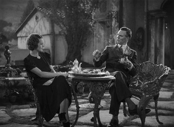 Movie still from “Dodsworth” (1936), directed by William Wyler – A man and a woman sitting at a table with food; Wide shot, High angle