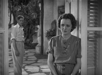 Movie still from “Dodsworth” (1936), directed by William Wyler – A woman standing in front of a man in front of a building; Medium shot, Low angle