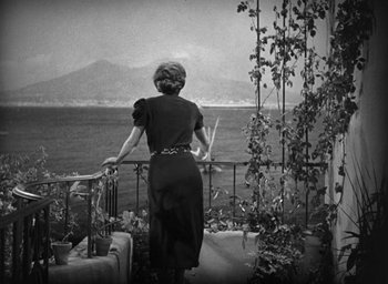 Movie still from “Dodsworth” (1936), directed by William Wyler – A black and white photo of a woman looking out over the water; Wide shot, High angle