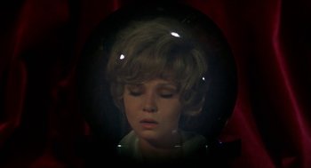 Movie still from “Family Plot” (1976), directed by Alfred Hitchcock – A woman with blonde curly hair looking into a mirror; Close Up shot, High angle