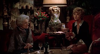 Movie still from “Family Plot” (1976), directed by Alfred Hitchcock – Two older women sitting at a table with wine glasses; Medium shot, Over the shoulder angle