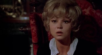 Movie still from “Family Plot” (1976), directed by Alfred Hitchcock – A woman with blonde hair and a white collar; Close Up shot, Over the shoulder angle