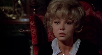 Movie still from “Family Plot” (1976), directed by Alfred Hitchcock – A woman with blonde hair sitting in front of a red chair; Close Up shot, Over the shoulder angle