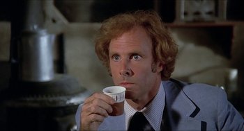 Movie still from “Family Plot” (1976), directed by Alfred Hitchcock – A man in a suit and tie holding a coffee cup; Close Up shot, Low angle