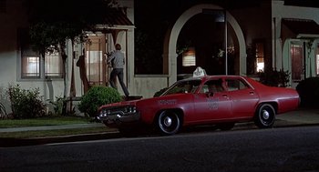 Movie still from “Family Plot” (1976), directed by Alfred Hitchcock – A red car parked on the side of the street; Wide shot, Low angle