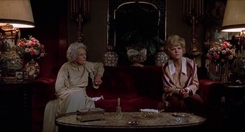 Movie still from “Family Plot” (1976), directed by Alfred Hitchcock – Two older women sitting on a couch in a living room; Wide shot, High angle