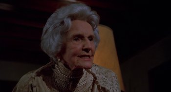 Movie still from “Family Plot” (1976), directed by Alfred Hitchcock – An old woman with a very large smile on her face; Close Up shot, Low angle