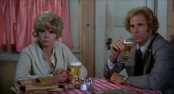 Movie still from “Family Plot” (1976), directed by Alfred Hitchcock – Two people sitting at a table with drinks; Close Up shot, Low angle