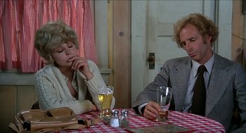 Movie still from “Family Plot” (1976), directed by Alfred Hitchcock – A man and a woman sitting at a table with drinks; Close Up shot, High angle