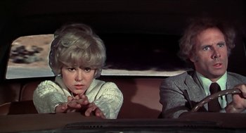 Movie still from “Family Plot” (1976), directed by Alfred Hitchcock – A woman sitting next to another woman in front of a computer monitor; Medium shot, High angle