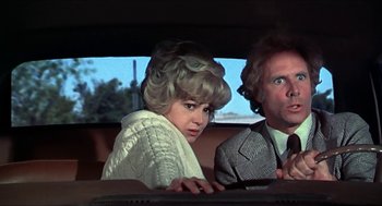 Movie still from “Family Plot” (1976), directed by Alfred Hitchcock – A woman and a man sitting in the back seat of a car; Close Up shot, Over the shoulder angle