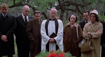 Movie still from “Family Plot” (1976), directed by Alfred Hitchcock – A group of men and women standing in front of a tree; Medium shot, Low angle