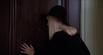 Movie still from “Family Plot” (1976), directed by Alfred Hitchcock – A woman with long blonde hair wearing a black hat; Close Up shot, High angle