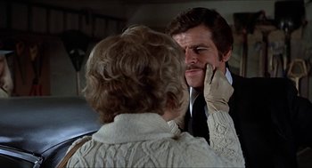 Movie still from “Family Plot” (1976), directed by Alfred Hitchcock – An older man and a younger woman in a room; Close Up shot, Over the shoulder angle