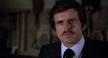 Movie still from “Family Plot” (1976), directed by Alfred Hitchcock – A man with a mustache wearing a suit and tie; Close Up shot, Low angle