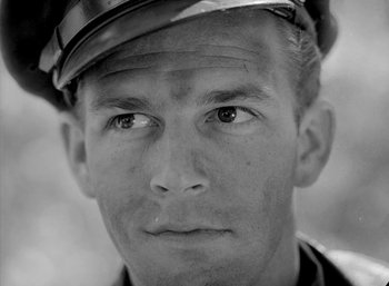 Movie still from “Fear and Desire” (1952), directed by Stanley Kubrick – Black and white photograph of a man wearing a hat; Close Up shot, Low angle