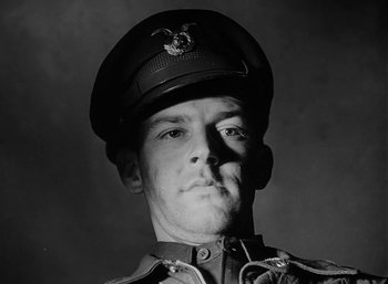 Movie still from “Fear and Desire” (1952), directed by Stanley Kubrick – A man in a military uniform wearing a hat; Close Up shot, Low angle