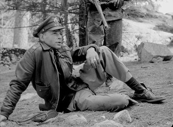 Movie still from “Fear and Desire” (1952), directed by Stanley Kubrick – An old photo of a man sitting on the ground; Medium shot, High angle