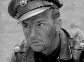Movie still from “Fear and Desire” (1952), directed by Stanley Kubrick – A man wearing a leather jacket and a hat; Close Up shot, High angle