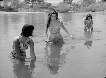 Movie still from “Fear and Desire” (1952), directed by Stanley Kubrick – Three young women in a body of shallow water; Wide shot, High angle