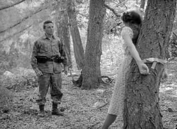Movie still from “Fear and Desire” (1952), directed by Stanley Kubrick – A man and a woman in the woods looking at each other; Wide shot, Low angle