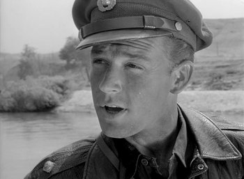 Movie still from “Fear and Desire” (1952), directed by Stanley Kubrick – A man in a military uniform is looking at the camera; Close Up shot, Over the shoulder angle