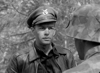 Movie still from “Fear and Desire” (1952), directed by Stanley Kubrick – A man in a military uniform wearing a hat; Close Up shot, Over the shoulder angle