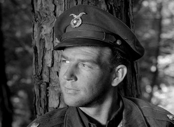 Movie still from “Fear and Desire” (1952), directed by Stanley Kubrick – A man wearing a military uniform and a hat; Close Up shot, Low angle