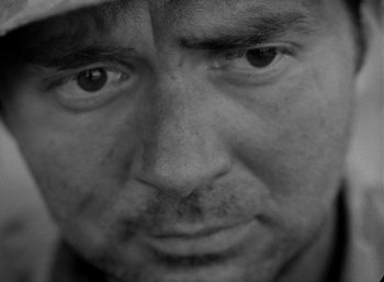 Movie still from “Fear and Desire” (1952), directed by Stanley Kubrick – Black and white close up of a man's face; Extreme Close Up shot, Low angle