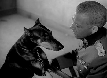 Movie still from “Fear and Desire” (1952), directed by Stanley Kubrick – A black and white photo of a man and a dog; Close Up shot, Low angle