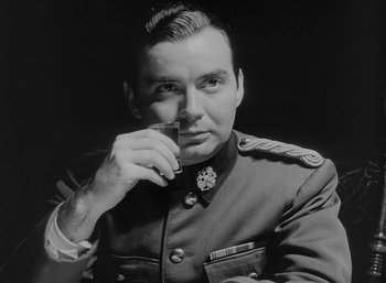 Movie still from “Fear and Desire” (1952), directed by Stanley Kubrick – A man in a military uniform is holding a cigarette; Close Up shot, Low angle