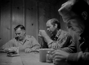 Movie still from “Fear and Desire” (1952), directed by Stanley Kubrick – A group of men sitting at a table drinking coffee; Medium shot, Low angle