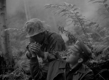 Movie still from “Fear and Desire” (1952), directed by Stanley Kubrick – A man in a military uniform and a man in a hat; Medium shot, High angle