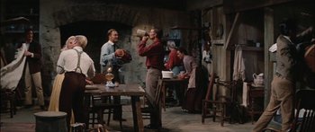 Movie still from “Flaming Star” (1960), directed by Don Siegel – A group of men and women in a living room; Wide shot, Low angle