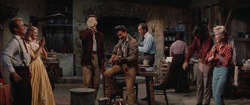 Movie still from “Flaming Star” (1960), directed by Don Siegel – A group of men sitting around a table; Wide shot, Over the shoulder angle