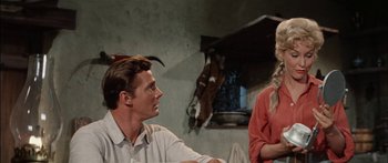 Movie still from “Flaming Star” (1960), directed by Don Siegel – A man and a woman sitting in front of a horse; Medium shot, Over the shoulder angle