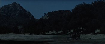 Movie still from “Flaming Star” (1960), directed by Don Siegel – A horse and carriage traveling down a road at night; Extreme Wide shot, High angle
