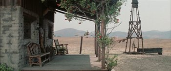 Movie still from “Flaming Star” (1960), directed by Don Siegel – A porch with a rocking chair and flowers on it; Extreme Wide shot, High angle