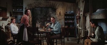Movie still from “Flaming Star” (1960), directed by Don Siegel – A man sitting at a table with a bowl of food; Medium shot, Over the shoulder angle