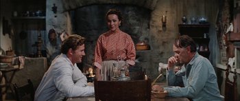 Movie still from “Flaming Star” (1960), directed by Don Siegel – A group of people sitting around a table; Medium shot, Over the shoulder angle