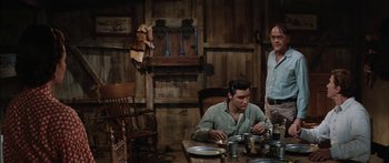 Movie still from “Flaming Star” (1960), directed by Don Siegel – Two men sitting at a table in a room; Medium shot, Over the shoulder angle