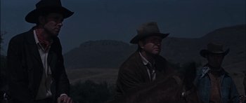 Movie still from “Flaming Star” (1960), directed by Don Siegel – A man wearing a hat riding on a horse; Medium shot, Low angle