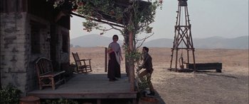 Movie still from “Flaming Star” (1960), directed by Don Siegel – A man and a woman standing under a tree; Wide shot, Low angle