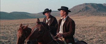 Movie still from “Flaming Star” (1960), directed by Don Siegel – A couple of men sitting next to each other on a horse; Medium shot, Over the shoulder angle