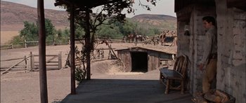 Movie still from “Flaming Star” (1960), directed by Don Siegel – A group of horses standing on top of a dirt field; Extreme Wide shot, High angle