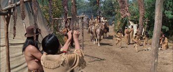 Movie still from “Flaming Star” (1960), directed by Don Siegel – A group of people on horses in the woods; Wide shot, Over the shoulder angle
